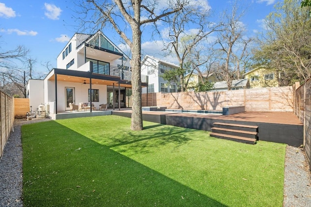 rear view of property featuring stucco siding, a lawn, a fenced backyard, an outdoor pool, and ceiling fan