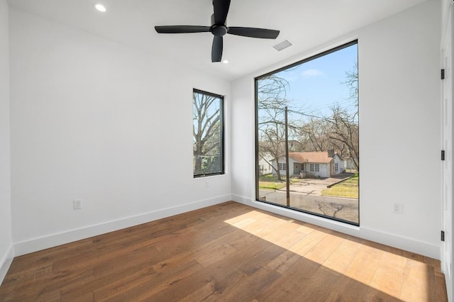 spare room featuring visible vents, ceiling fan, baseboards, recessed lighting, and hardwood / wood-style flooring