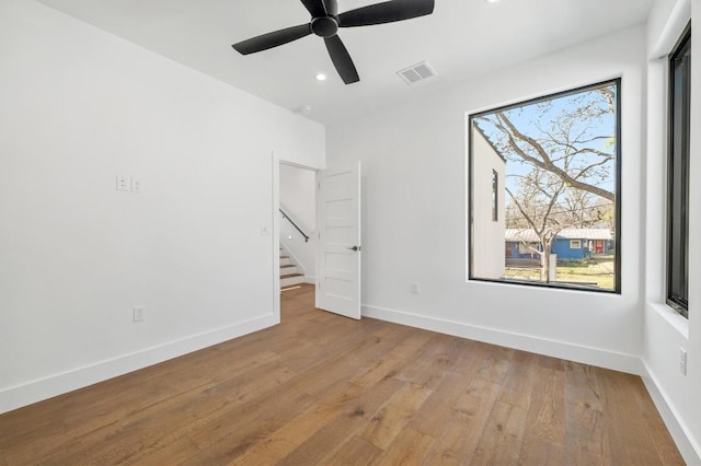 spare room featuring visible vents, baseboards, recessed lighting, hardwood / wood-style flooring, and a ceiling fan