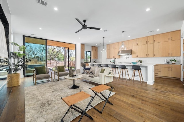 living area featuring visible vents, recessed lighting, a wall of windows, and dark wood-style flooring