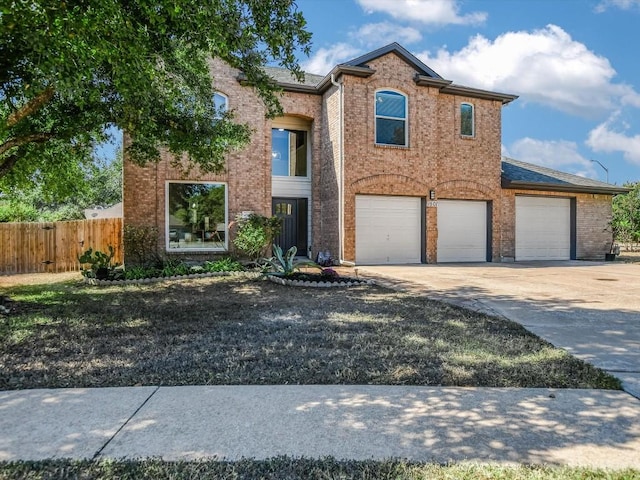 view of front of property featuring brick siding, driveway, an attached garage, and fence