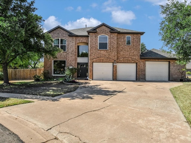 traditional-style home with brick siding, roof with shingles, driveway, and fence