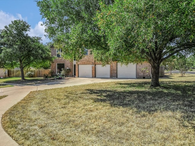 obstructed view of property with brick siding, concrete driveway, a front lawn, and fence