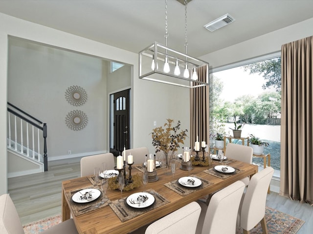 dining area featuring visible vents, baseboards, stairs, and light wood finished floors