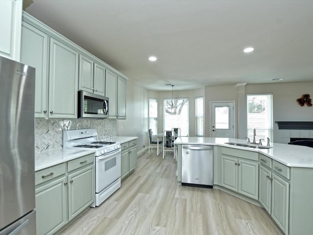 kitchen featuring a sink, stainless steel appliances, tasteful backsplash, and a wealth of natural light