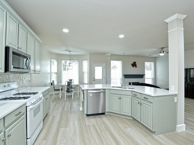 kitchen featuring a sink, light countertops, a wealth of natural light, and stainless steel appliances