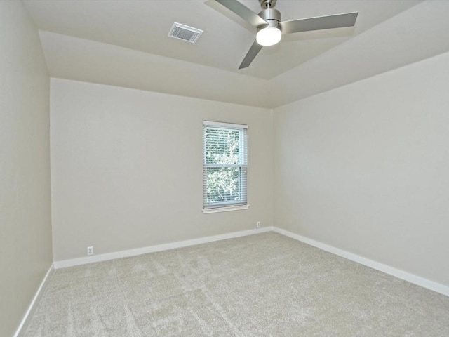 carpeted spare room featuring visible vents, ceiling fan, and baseboards