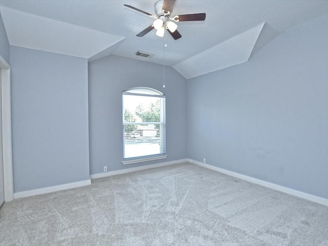 empty room featuring visible vents, carpet floors, baseboards, ceiling fan, and vaulted ceiling