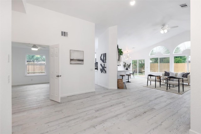 interior space featuring high vaulted ceiling, wood finished floors, visible vents, and baseboards