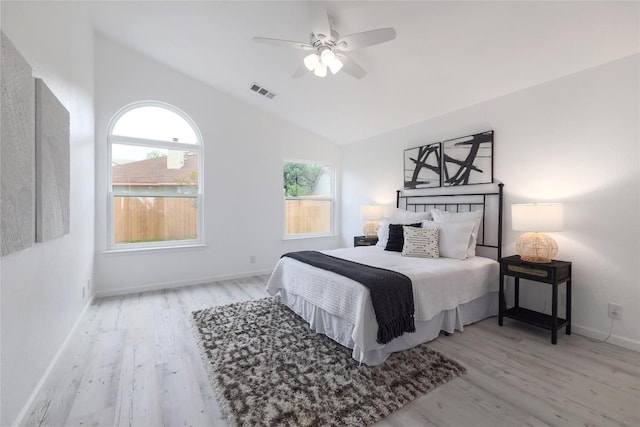 bedroom featuring visible vents, baseboards, lofted ceiling, and wood finished floors