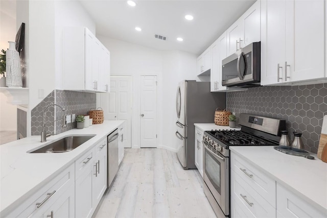 kitchen featuring a sink, stainless steel appliances, visible vents, and white cabinetry