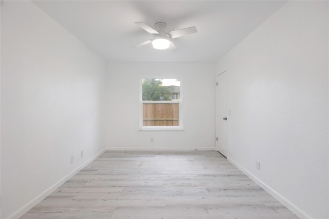 spare room with light wood finished floors, baseboards, and a ceiling fan