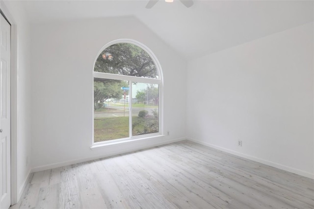 unfurnished room featuring baseboards, lofted ceiling, a ceiling fan, and wood finished floors