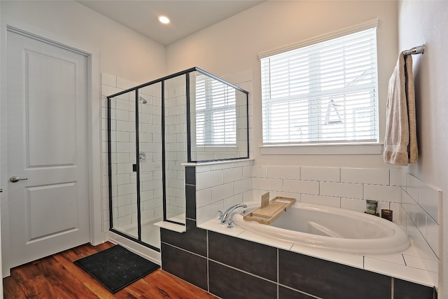 full bath with a garden tub, wood finished floors, and a stall shower