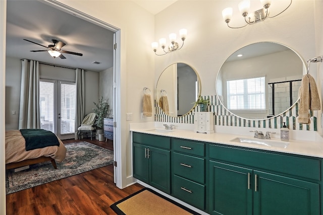 full bathroom with a healthy amount of sunlight, wood finished floors, ensuite bathroom, and a sink