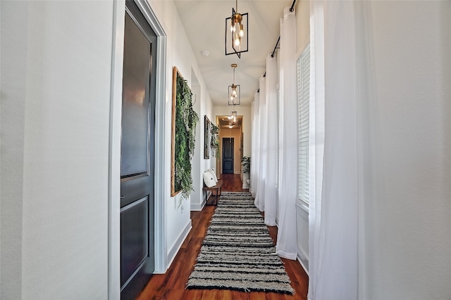 corridor featuring dark wood finished floors and baseboards