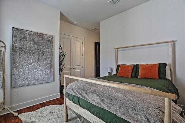 bedroom featuring visible vents, baseboards, and wood finished floors