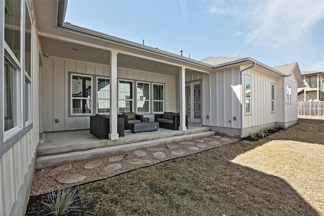 rear view of house with an outdoor living space, a patio, and board and batten siding