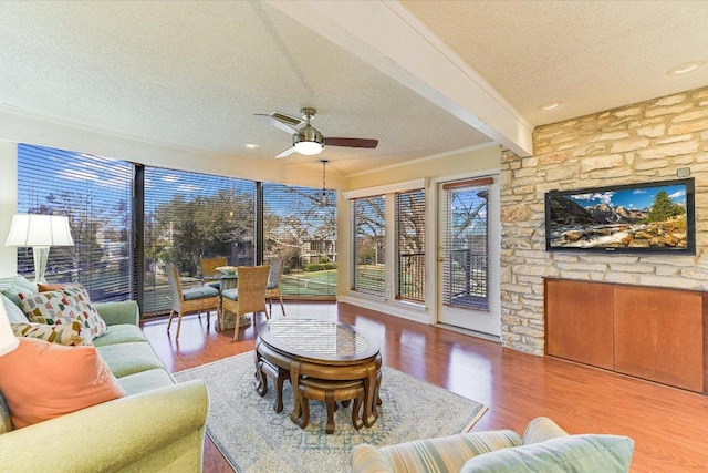 sunroom / solarium featuring beam ceiling and a ceiling fan