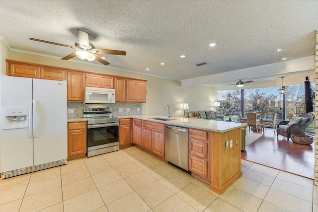 kitchen featuring a sink, open floor plan, appliances with stainless steel finishes, light tile patterned flooring, and ceiling fan