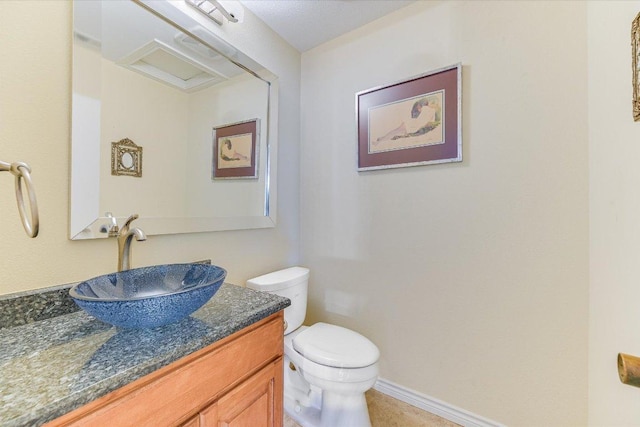 bathroom featuring vanity, toilet, and baseboards