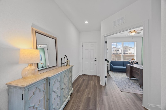 corridor with recessed lighting, visible vents, baseboards, and dark wood-style floors