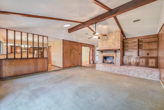 unfurnished living room with wooden walls, ceiling fan, carpet flooring, and a textured ceiling