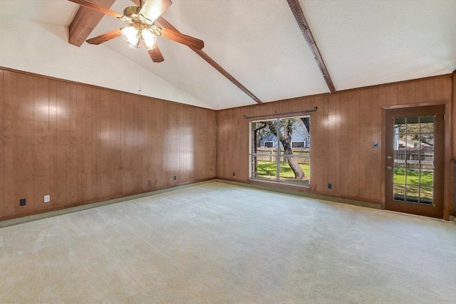 unfurnished room featuring light carpet, beam ceiling, ceiling fan, and wood walls