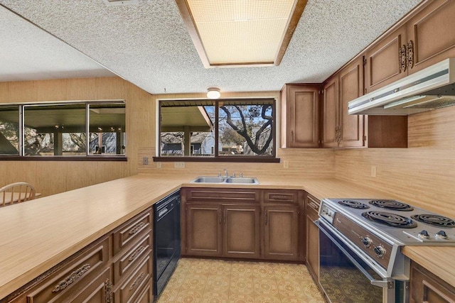 kitchen featuring under cabinet range hood, light floors, light countertops, black dishwasher, and electric range