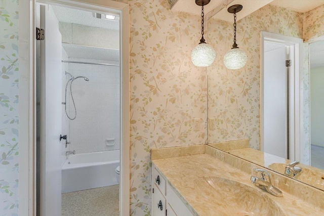 full bathroom with toilet, vanity, and wallpapered walls