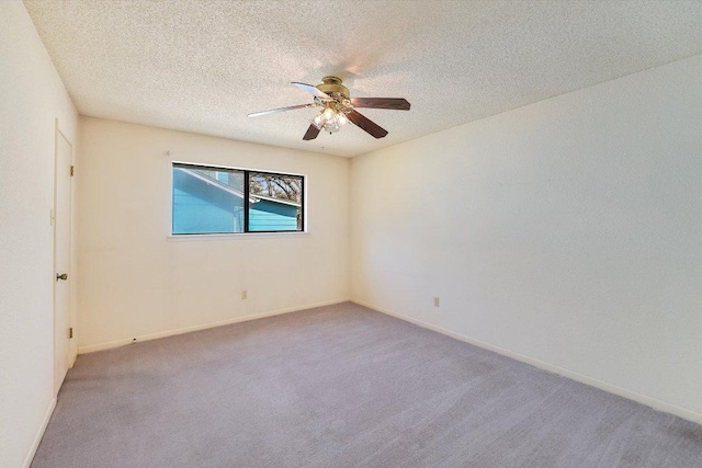 spare room featuring baseboards, a textured ceiling, ceiling fan, and carpet flooring