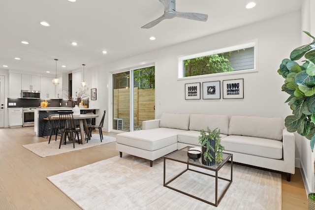 living area with recessed lighting, light wood-style floors, and a ceiling fan