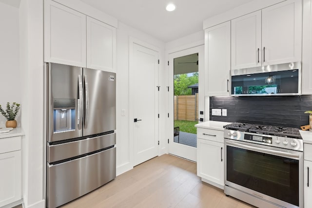 kitchen featuring appliances with stainless steel finishes, white cabinets, and light wood finished floors