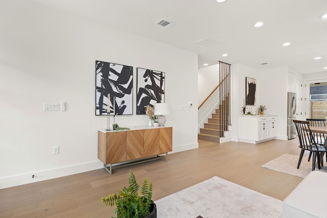 interior space featuring recessed lighting, visible vents, light wood-style flooring, and stairs