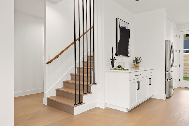 stairs with baseboards and wood finished floors