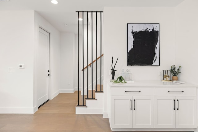 bar featuring recessed lighting, stairway, light wood-style flooring, and baseboards