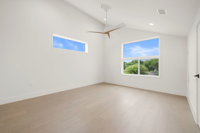 empty room featuring visible vents, light wood-style flooring, baseboards, lofted ceiling, and ceiling fan