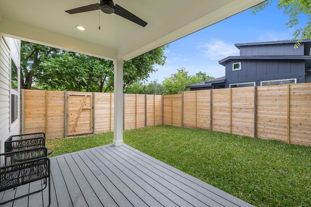 wooden terrace featuring a fenced backyard, a lawn, and a ceiling fan