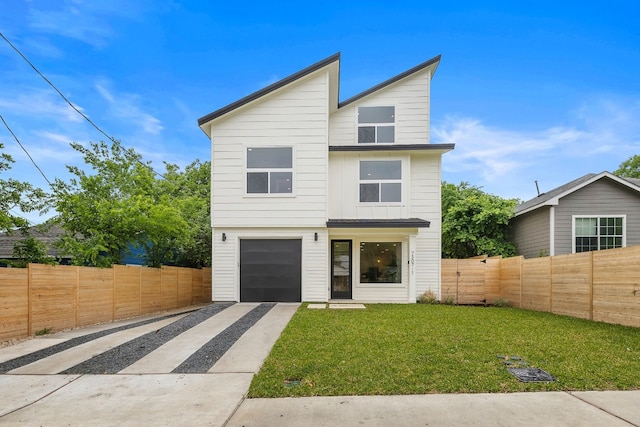 contemporary house with a front lawn, fence, a garage, and driveway