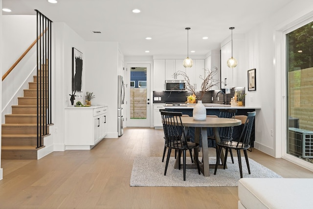 dining space with visible vents, recessed lighting, light wood finished floors, baseboards, and stairs