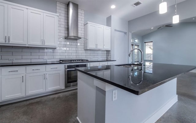 kitchen featuring visible vents, backsplash, wall chimney range hood, stainless steel appliances, and a sink