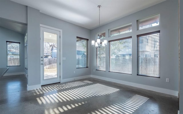 unfurnished dining area featuring plenty of natural light, baseboards, and an inviting chandelier