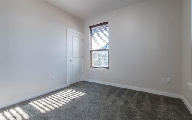 unfurnished room with carpet flooring and baseboards