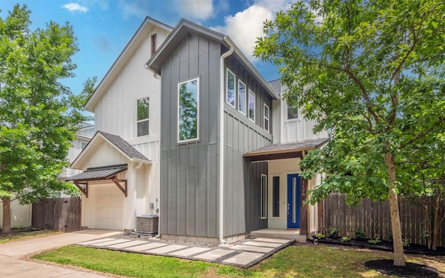 1128 Gunter St Unit B, Austin, TX 78702 - view of front of home featuring driveway, an attached garage, board and batten siding, and central AC