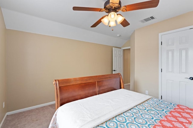 carpeted bedroom with a ceiling fan, vaulted ceiling, baseboards, and visible vents