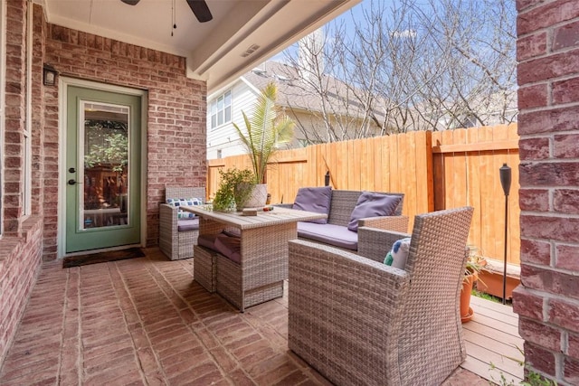 view of patio / terrace with a ceiling fan, fence, and outdoor lounge area