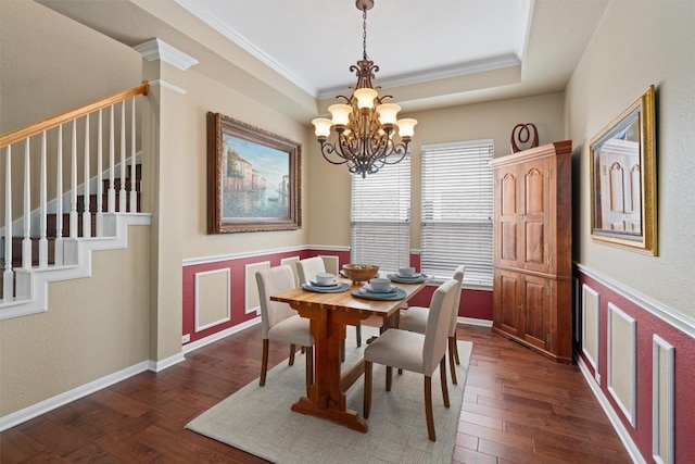 dining room featuring stairway, dark wood finished floors, crown molding, a raised ceiling, and a chandelier