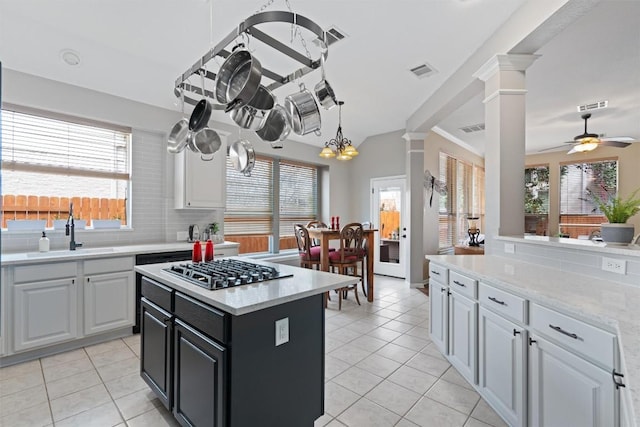 kitchen featuring gas stovetop, visible vents, backsplash, and a sink