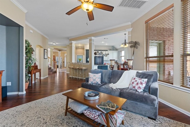 living area featuring visible vents, ceiling fan, ornamental molding, wood finished floors, and ornate columns