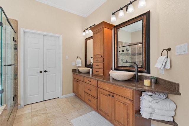 full bathroom featuring a shower stall, crown molding, double vanity, tile patterned floors, and a sink